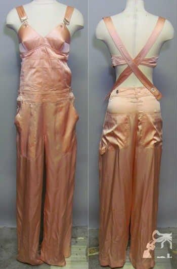 Femme (printemps-été 2010) (modèle de défilé, look n°36) SALOPETTE en satin de soie rose poudre, bavette rehaussée d'un soutien-gorge à poitrine préformée pointue et d'une poche, bretelles munies d'attaches métalliques façon 'porte-jarretelle', taille agrémentée de passants sur petit boutonnage de chaque côté, pantalon droit à quatre poches plaquées (griffe noire, graphisme blanc) (T36) (petite salissure)
