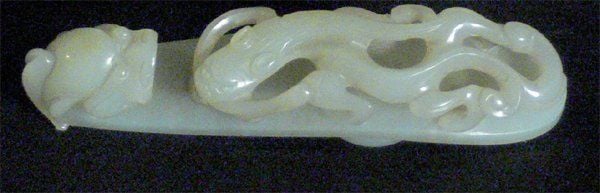 Fibule en jade néphrite céladon, le corps sculpté d'un dragon avançant vers l'extrémité recourbée en forme de tête de drago