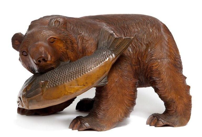 Figurine en bois sculptée par le peuple aïnou représentant un ours portant dans sa gueule un saumo