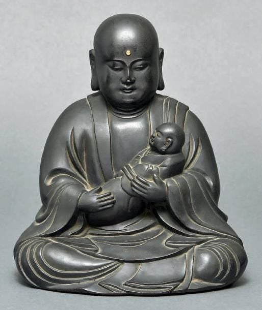 FIGURINE en bronze représentant Amida Bouddha assis et tenant un nourrisson dans ses bra