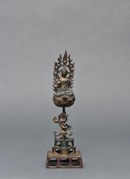 Figurine en bronze représentant un Bouddha devant une auréole flamboyant