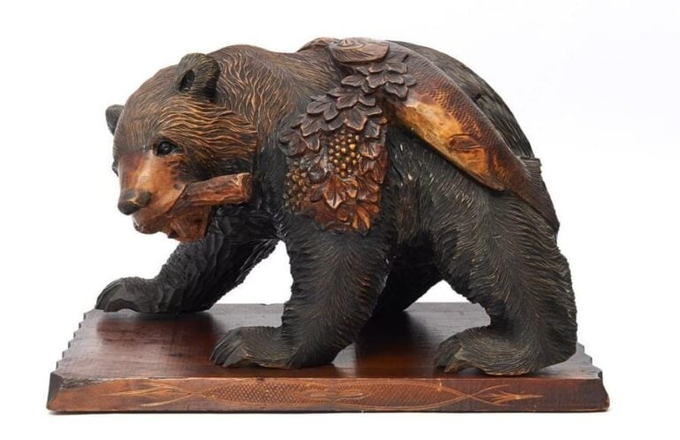 Figurine sculptée par le people Ainou représentant un ours tenant dans sa gueule une branche à feuilles sur laquelle est embroché un saumo