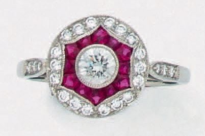 Fine BAGUE circulaire en platine (950 millièmes) serti de diamants taille brillant dont un, au centre, plus important entouré de rubis calibré