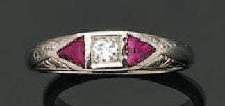Fine BAGUE en or gris ciselé serti d'un diamant taille brillant épaulé de deux rubis de forme triangulair