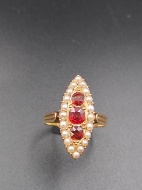 Fine BAGUE «marquise» en or jaune (750 millièmes), serti de trois grenats entourés de demi- perle