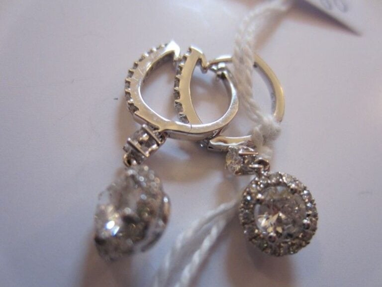 Fine PAIRE de PENDANTS D'OREILLES en or gris articulé serti d'un alignement de diamants taille brillant retenant un motif circulaire serti d'un diamant taille brillant entouré de petits diamant