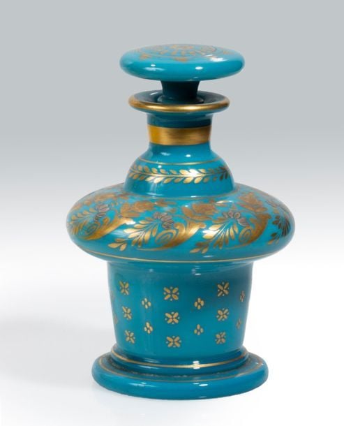 Flacon à bulbe et piédouche en opaline de cristal turquoise à décor doré de rinceaux et rameaux fleuris stylisés, d'un bandeau de feuilles stylisées, de filets et d'un semis de croix et de points; bouchon plat à motif rayonnant dor