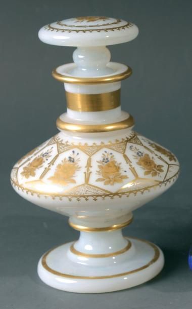 Flacon biconique sur pied et son bouchon en opaline de cristal savonneuse à décor doré formant dix réserves ornées de fleurettes dorées et de myosotis bleus; filets dorés au pied et au col; bouchon plat orné d'une fleurette doré