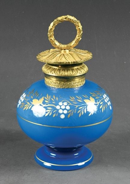 Flacon boule sur piédouche en opaline de cristal lavande à décor Desvignes de pampres de vignes blancs et dorés; col et haut de bouchon ciselés en bronze doré; prise en forme de couronne de feuillag