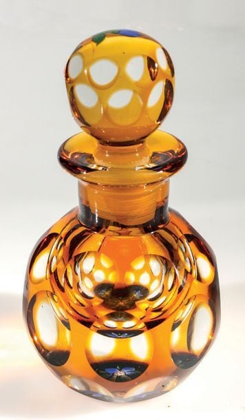 Flacon overlay ambre signé P, la base et le bouchon ornés en inclusion d'une fleurette bleu