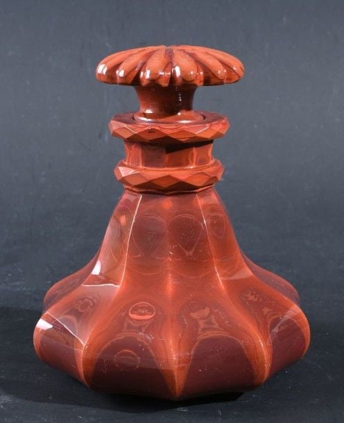 Flacon piriforme et son bouchon en lithyaline rouge imitant la pierre dure, taillée à côtes plates; bouchon taillé à côtes rayonnante
