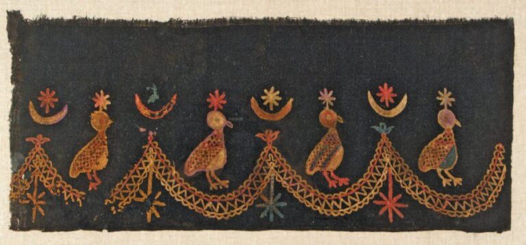 FRAGMENT DE BRODERIE Toile noire décorée d'une succession d'oiseaux parmi des croissants et des étoiles, séparés par une bande en feston