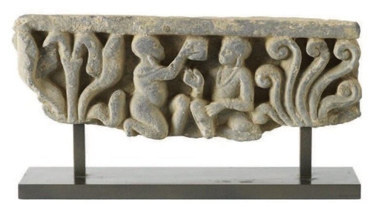 Fragment de frise Schiste gris Art Gréco-bouddhique du Gandhara, Ier - IIIe siècle Hauteur: 12; Largeur: 34 cm Deux personnages agenouillés et se faisant face sont encadrés de palmettes exubérantes