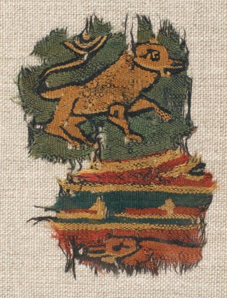 FRAGMENT DE TAPISSERIE Fragment polychrome décoré d'un lion et d'une inscription coufique à fond ver