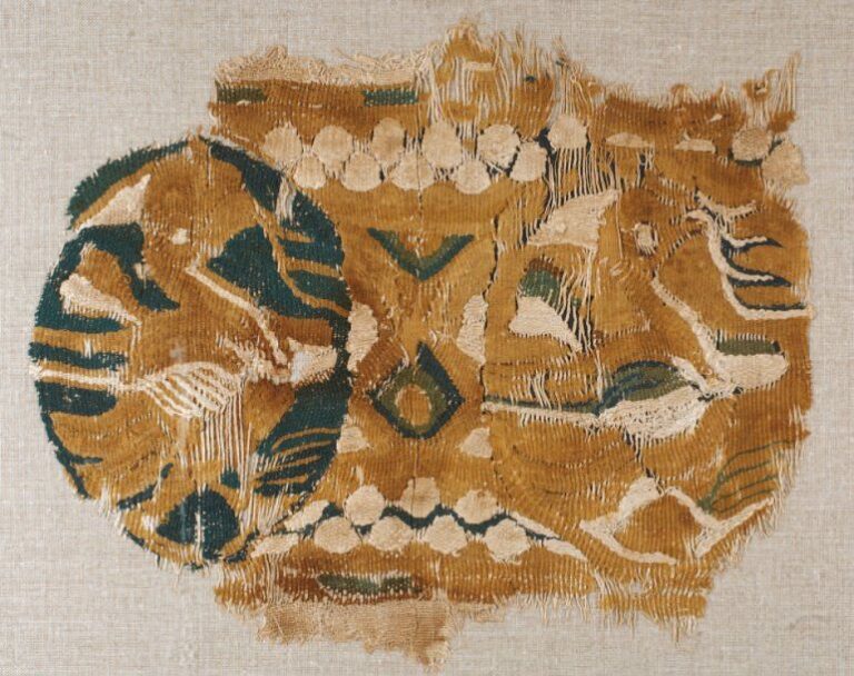 FRAGMENT DE TAPISSERIE Fragment polychrome décoré de deux oiseaux dans des rondeaux, le cou ceint d'un ruban, un rameau dans le be