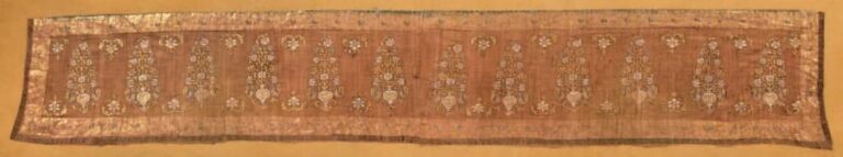 Fragment de voile moghol Textile peint et doré Ce très fin textile peint et doré, est à décor de vases de fleurs entourés de paons, alternés de fleurs placées en haut et en bas de la frise centrale, entouré d'une bande sur fond o
