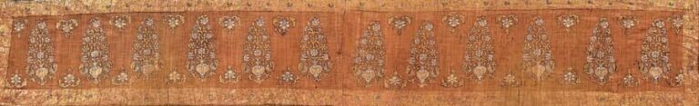 Fragment de voile moghol Textile peint et doré Inde du Nord, XVIIIe siècle, Epoque Moghole Hauteur: 21; Largeur: 120 cm Ce textile est orné d'une frise de paons affrontant des vases d'où jaillissent des bouquet
