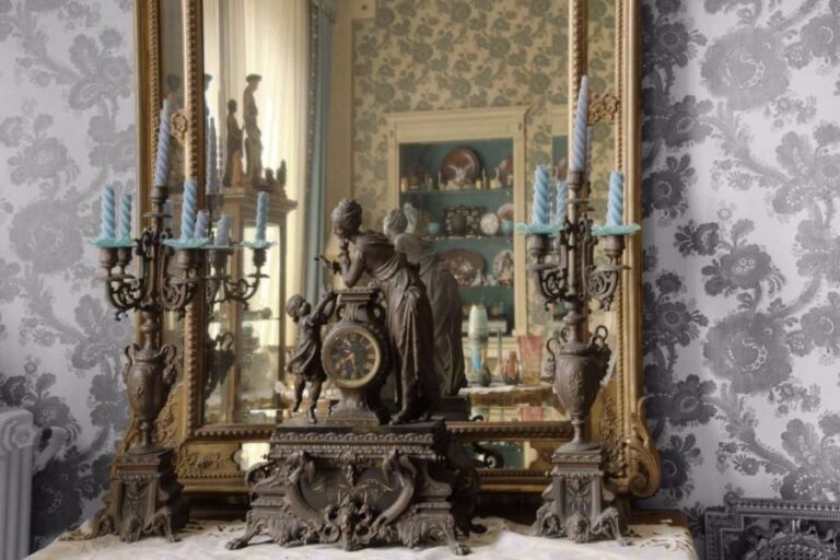 Garniture de cheminée en régule comprenant une pendule stylisant une mère et sa jeune fille et une paire de candélabres à cinq lumières, le fut en forme de vase ovoid
