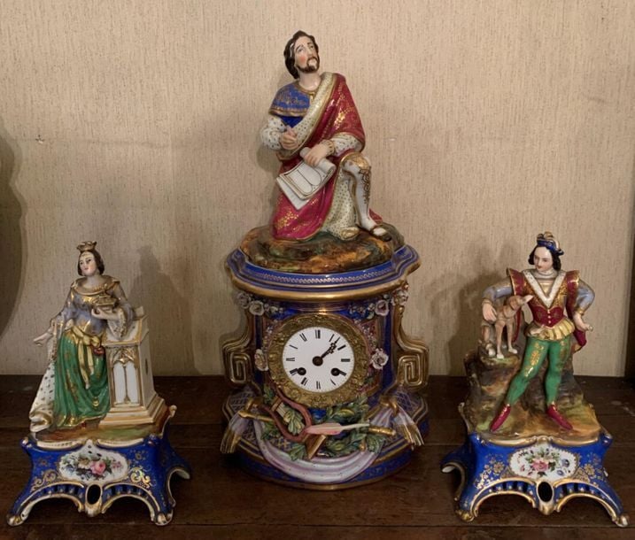 Garniture en Porcelaine de Paris à décor troubadour comprenant une pendule sommée d'un poète et d'un couple en habit d'époqu
