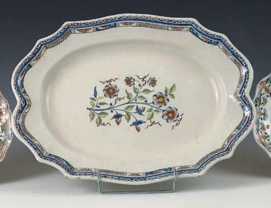 Grand plat ovale à bord contourné, décor polychrome d'une gerbe de fleurs au centre et de guirlandes et croisillons sur le bor