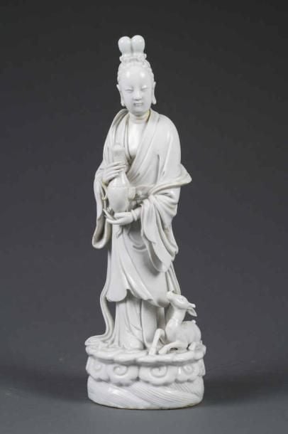 GRAND SUJET EN PORCELAINE EMAILLEE "BLANC DE CHINE" MOULE A L'EFFIGIE DE LA DEESSE MAGU Chine, Fujian, Fours de Dehua, Dynastie Qing, Epoque XVIIIe/XIXe siècle La déesse est représentée debout, tenant une théière, une biche couchée à ses côtés (petits manques, éclats et restaurations, dont la tête recollée