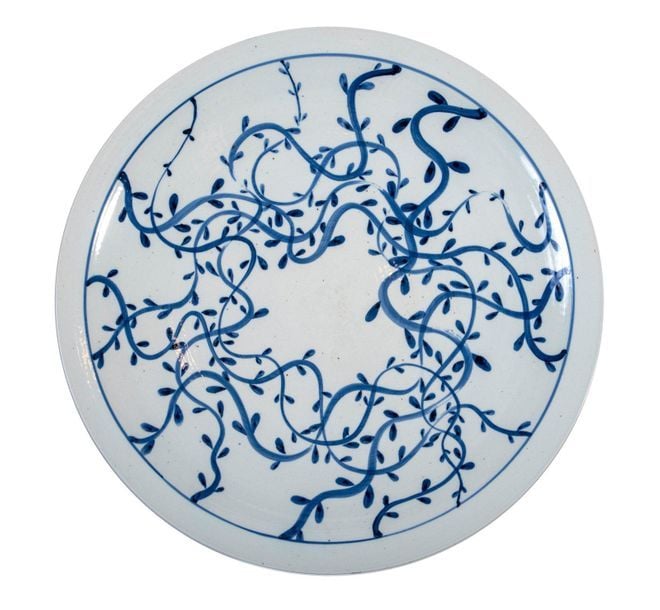 Grande assiette en porcelaine bleue et blanche décorée de volutes florales abstraite