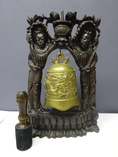 GRANDE CLOCHE DE TEMPLE AVEC SON SUPPORT EN BOIS A L'EFFIGIE DE DEUX FEMMES