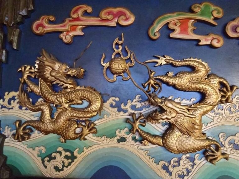 GRANDE ET SPECTACULAIRE FRISE DECORATIVE EN BOIS POLYCHROME A DECOR DE NEUF DRAGONS A CINQ GRIFFES Chine, Seconde moitié du XXe siècle Formée de trois panneaux s'encastran
