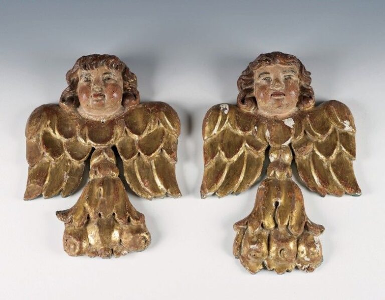 Grande paire d’angelots en tilleul sculpté, laqué ou doré, ils sont représentés tenant du bras droit un flambeau à cannelures rudentées et portant des drapés en toile enduite et doré