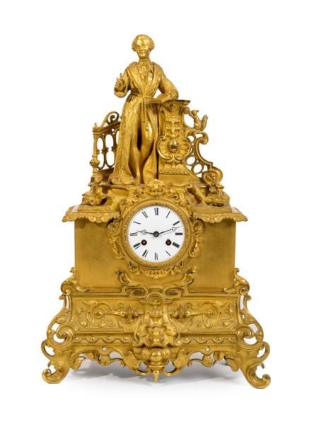 Grande pendule en bronze doré et ciselé surmonté d'un personnage écrivan