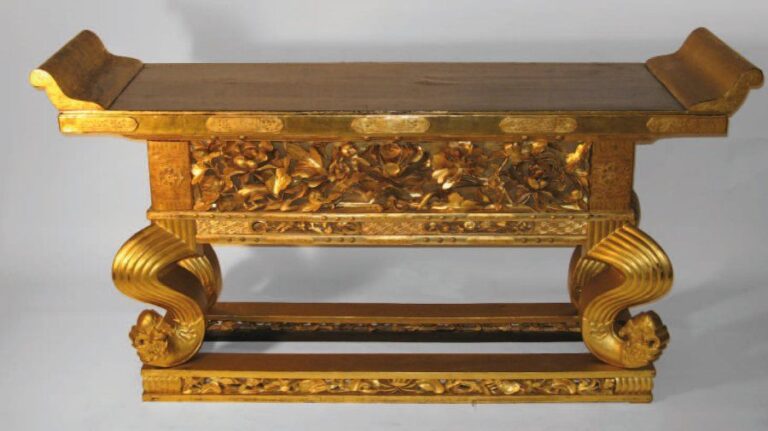 Grande table de temple en bois laqué noir, à décor de fleurs sculptées et motifs ornementaux     doré