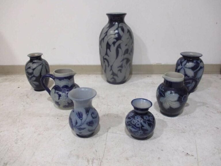 GRES D'ALSACE Ensemble comprenant cinq vases et deux pichets en grès d'Alsace à décor de motifs floraux, grappes de raisins et feuilles de vigne sur un fond bleu-marin