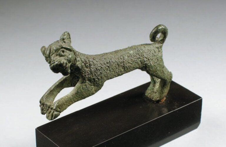 GUÉPARD Statuette de guépard bondissant, tête tournée de côté, le corps gravé d'ocelle