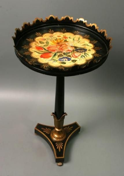 Guéridon en tôle noircie; plateau à bord dentelé et décor de fleurs polychromes dans une réserve jaune à filet godronné et palmettes dorées; base tripode à décor de palmettes dorée