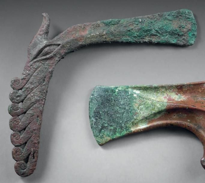 Hache à collet présentant un motif de mèches et un oeil en amande en relief qui semble représenter une tête de cheval stylisé
