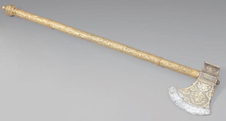 Hache indienne Acier couvert d'une épaisse couche de vermeil, manche en cuivre doré Cette luxueuse hache possède une tête en acier recouverte d'une épaisse argenture en partie dorée, gravée de bouquets de fleurs inscrits dans des cartouches polylobés sur un fond entièrement cisel