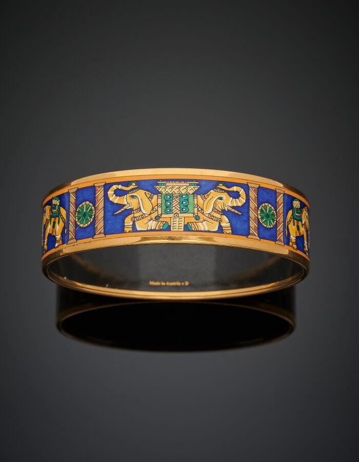 HERMES - BRACELET manchette métal doré, orné de laque à motifs de huit éléphant…