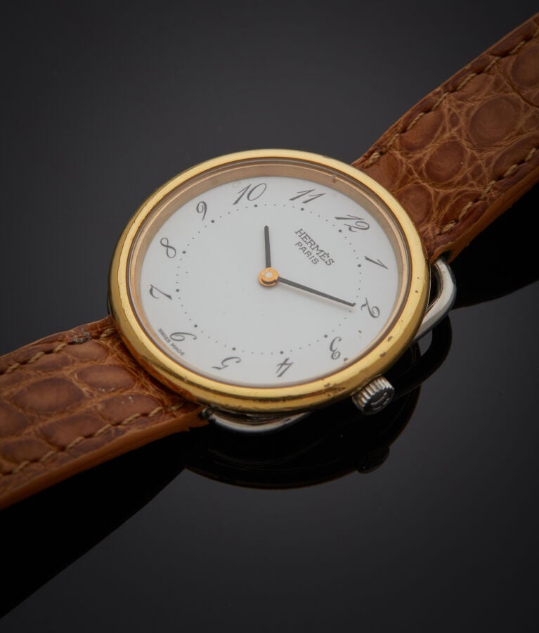 HERMES - BRACELET MONTRE ronde "Arceau" en métal. Une attache ajourée, cadran b…