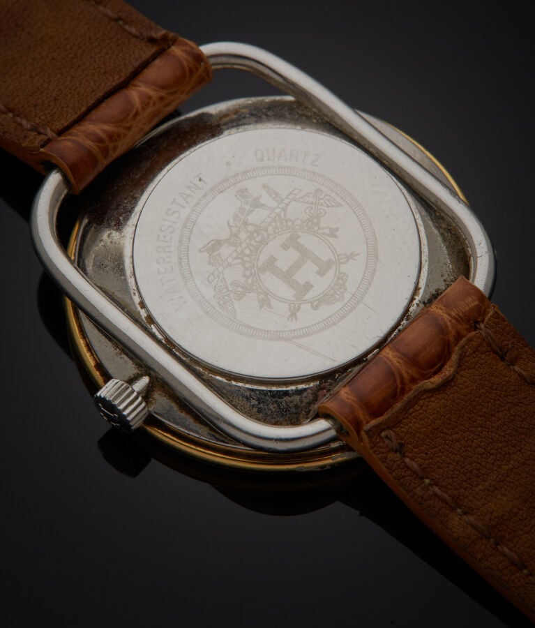 HERMES - BRACELET MONTRE ronde "Arceau" en métal. Une attache ajourée, cadran b…