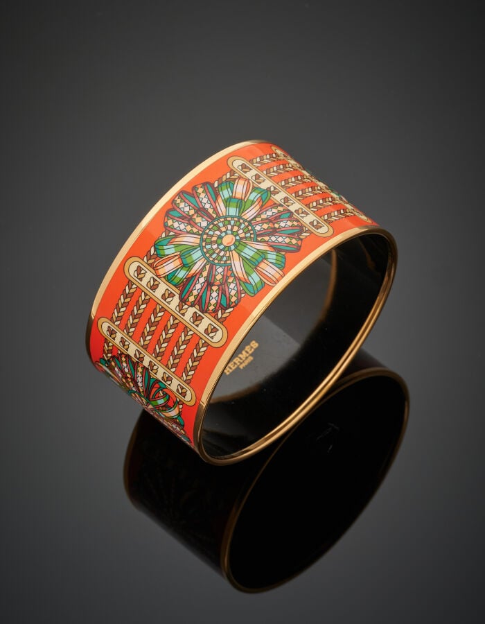 HERMES - Large BRACELET manchette métal doré, orné de laque orange à motifs de…