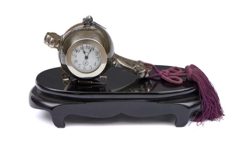 Horloge sur un socle de forme ovale et garni de laque noir