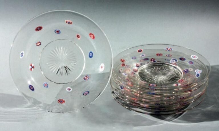 Huit assiettes en cristal, les ailes ornées chacune de seize bonbons polychromes dont certains à fléchette