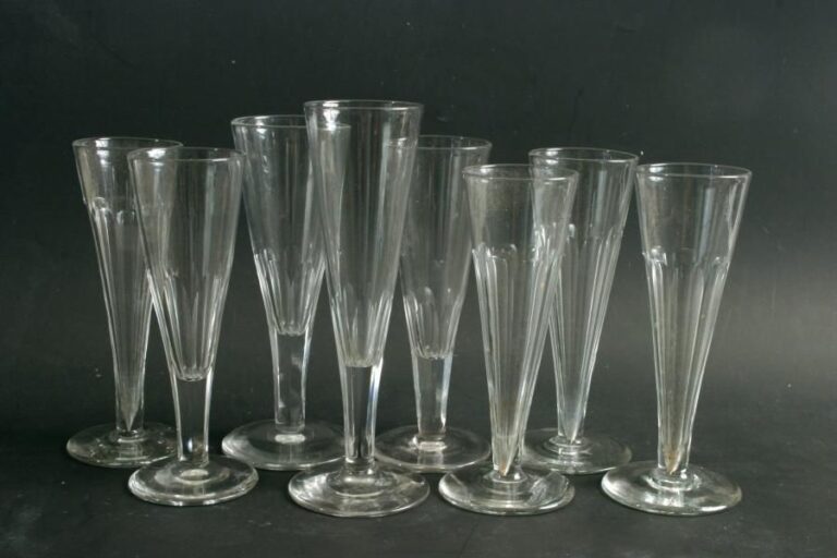 Huit flûtes à champagne à coupes coniques, dont trois de Saint-Louis, en cristal partiellement taillé à côtes plate