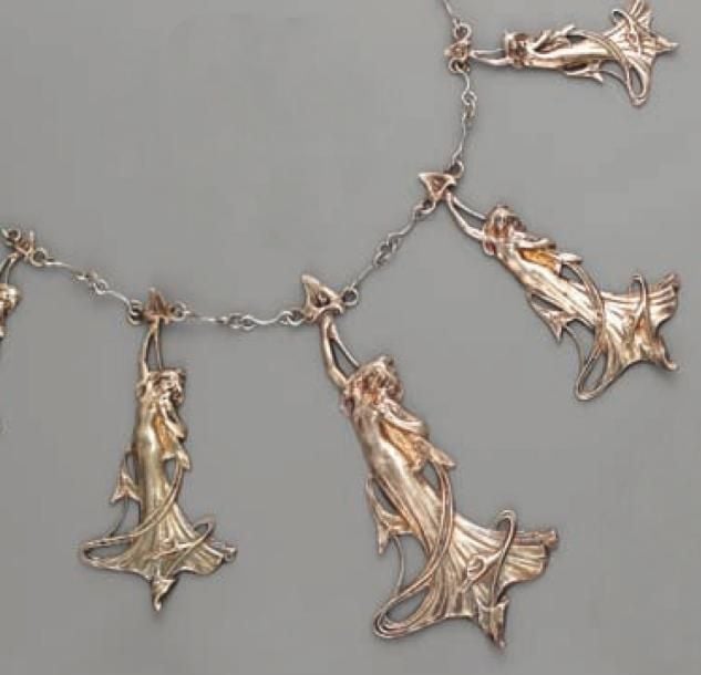 Important COLLIER en métal argenté composé d'une chaînette retenant cinq motifs de « femmes à l'arôme », en chut