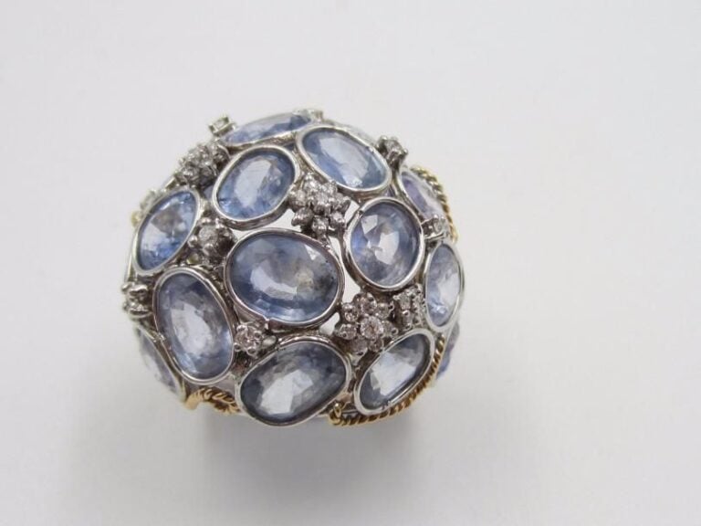 Importante BAGUE « boule » en or gris et or jaune (750 millièmes) torsadé et ajouré serti de saphirs ovales rehaussés de diamants, à motifs de fleurette