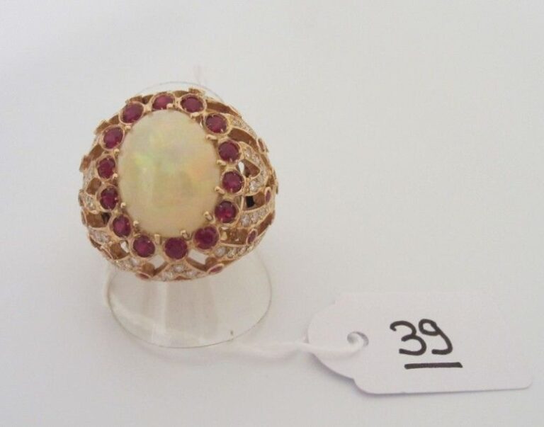 Importante BAGUE «boule» en or rose (750 millièmes) ajouré serti d?une opale cabochon de forme ovale, de rubis et diamant