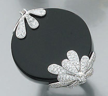 Importante BAGUE circulaire, en or gris serti d'onyx rehaussé de diamants à motifs de fleur