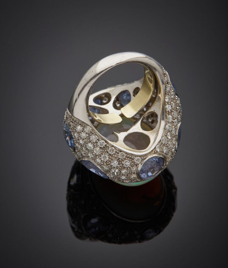 Importante BAGUE en or gris (750‰), orné d'une opale de forme ovale (fêles), en…