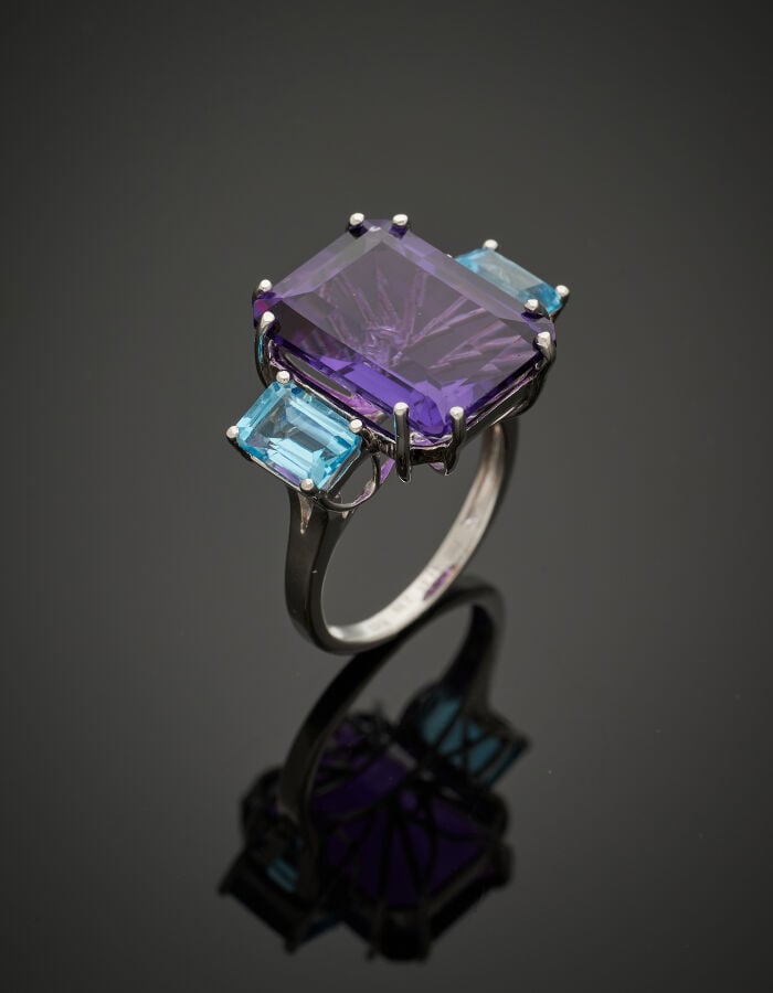 Importante BAGUE en or gris (750‰) serti d'une améthyste, épaulée de deux topaz…