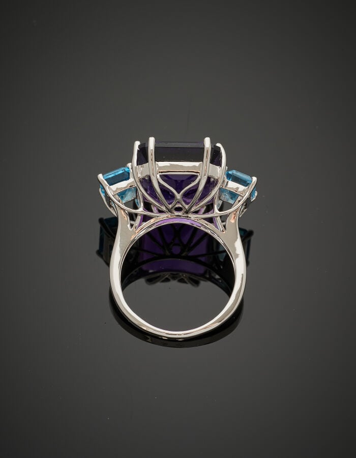 Importante BAGUE en or gris (750‰) serti d'une améthyste, épaulée de deux topaz…